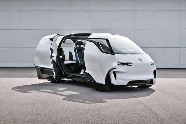 porsche minivan concept with sliding doors open parked in front of a large garage door