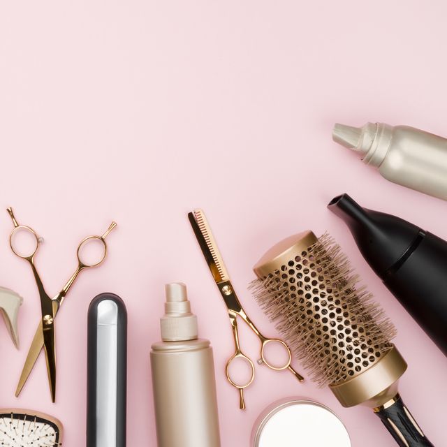 various hair dresser tools on pink background with copy space