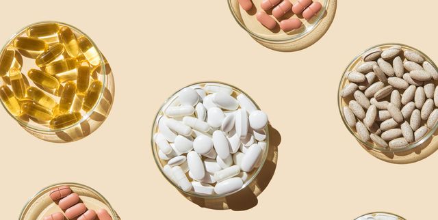 various pills and capsules, vitamins and dietary supplements in petri dishes on a beige background