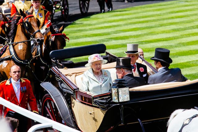 royal ascot race meeting at the prestigious ascot racecourse in berkshire royal procession arrival of members of the royal family queen elizabeth ii and prince philip sitting in a horse drawn carriage with two men accompanied by men wearing military uniform walking and on horse back