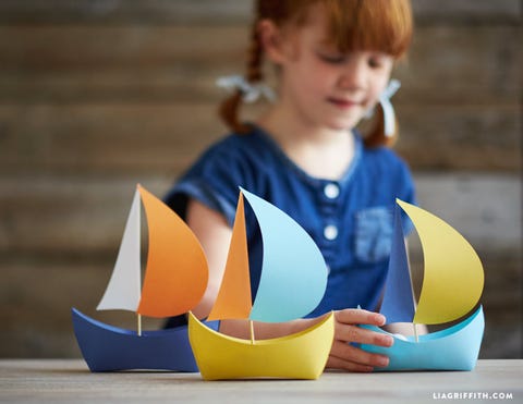 girl making a paper boat craft