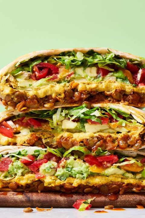 vegan crunchwraps stacked on a wooden cutting board