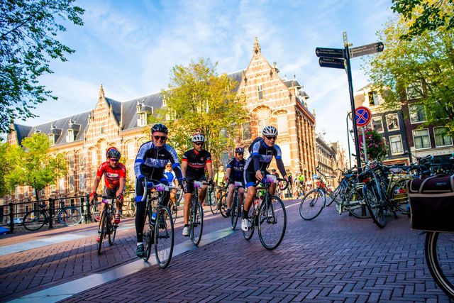 wielrenners fietsen door het centrum van amsterdam