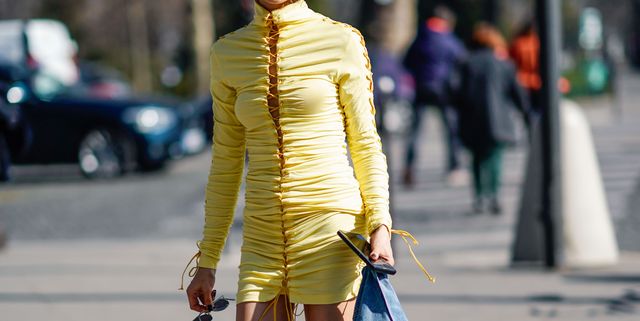 paris, france   february 27 a guest wears a yellow fitted mini dress, a blue and white denim jacket, black boots, outside unravel project, during paris fashion week womenswear fallwinter 20192020, on february 27, 2019 in paris, france photo by edward berthelotgetty images