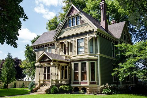 large green victorian house on a bright green lawn