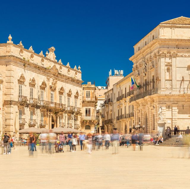 view of the central square in ortygia ortigia, piazza duomo with walking people historical buildings in the famous sicilian town syracuse siracusa, italy