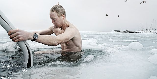 un hombre se baña en agua fría en un lago helado