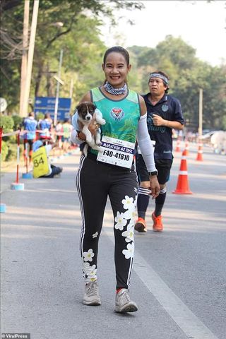 woman runs marathon carrying dog
