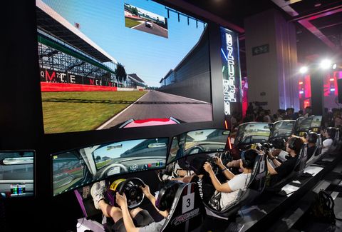 visitors play a car race game during the e sports and music