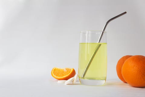 vitamin c soluble effervescent tablets in a glass of water with a stainless straw orange he drink enhances immunity and resistance to viruses