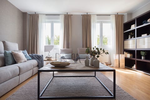 salón moderno decorado en beige con mesa de centro de madera y metal