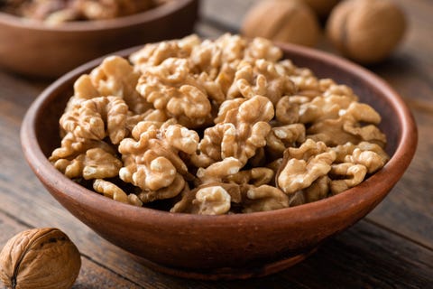 walnuts in brown bowl on wooden table