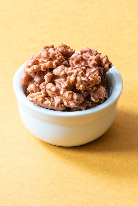 Best Fat Burning Foods - Walnuts a white bowl of walnuts on a yellow background, a good housekeeping pick for a healthy weight loss food