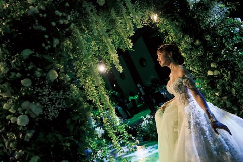 結婚式当日、会場にしつらえたフラワーアーチの下にたたずむ舟山久美子さんの画像