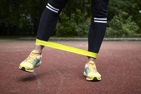 Vrouw traint op de atletiekbaan met een weerstandsband