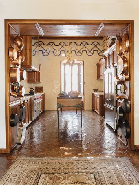 fisher emblazoned the kitchens floor to ceiling tilework with a hand painted border and the flooring is hand burnished local terra cotta
