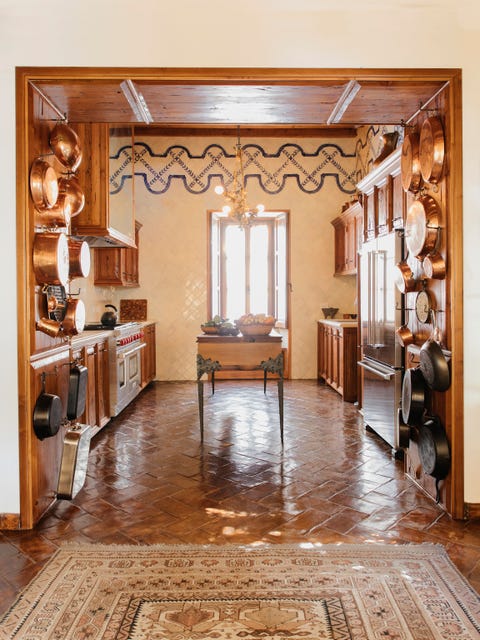 fisher emblazoned the kitchens floor to ceiling tilework with a hand painted border and the flooring is hand burnished local terra cotta