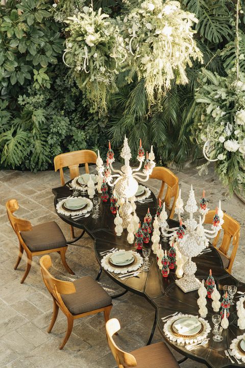 red candles embellished by oaxacan artists and pale green talaveran pottery bring enchanting christmas color to the table