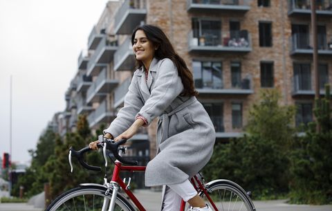 Jong vrouw op de fiets van haar werk