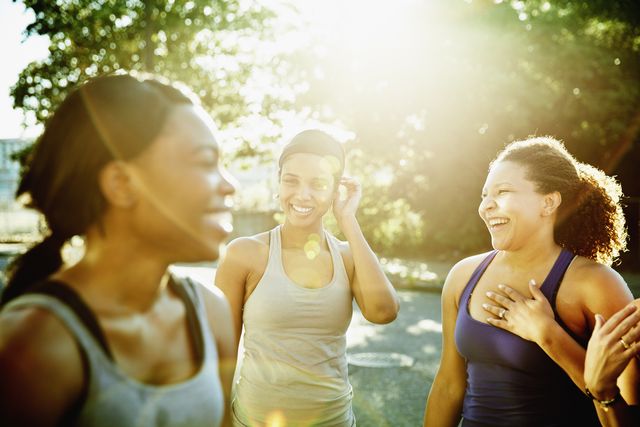 friends laughing together after morning run in downtown neighborhood