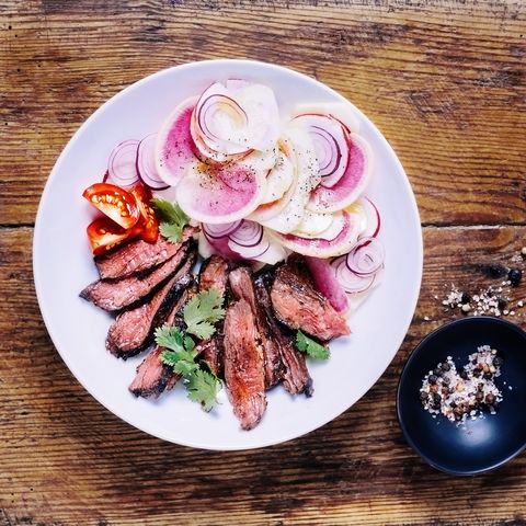 what to eat during your period for energy a sliced steak with fresh salad on a plate on wooden background
