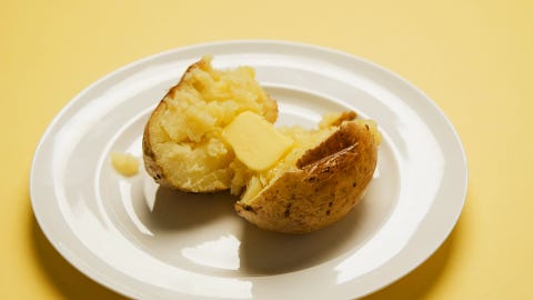 baked potato in the oven with butter