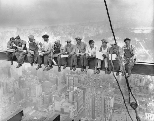 obreros descansando en una viga construyendo un rascacielos en nueva york