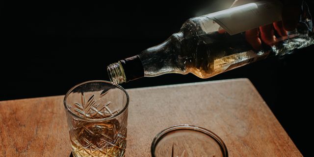whisky pour from a bottle into a cut glass tumbler