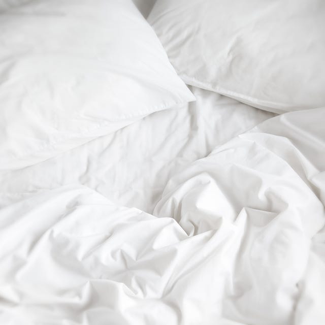 a top view of a messy bed and two pillows