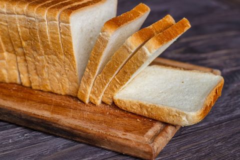 White bread sliced with slices on a wooden background close-up.