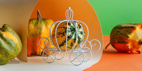 white miniature wire carriage and decorative pumpkin the concept of a holiday, a fairy tale, a rich harvest selective focus, layout for design