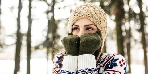 Vrouw heeft het koud met muts en handschoenen