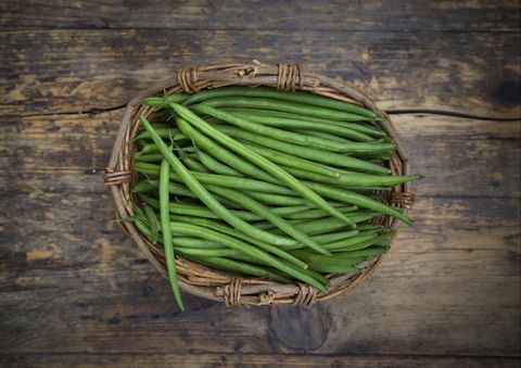 wickerbasket of green beans on dark wood