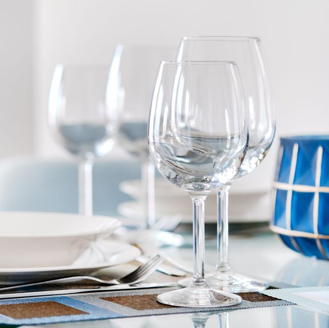 table setting with empty wine glasses, white plates bowls and flatware served on table close up of tableware, dishes, nobody preparation for dinner and guests reception