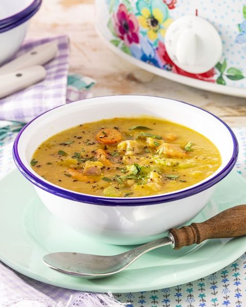 slow cooker split pea soup in white and blue bowl with wood spoon