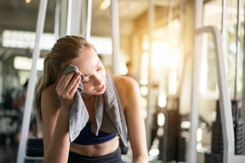 wiping sweat with towel.Tired man resting from sport training Image is intentionally toned.