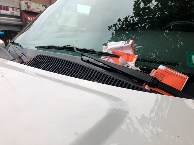 suv with several parking tickets in windshield wipers