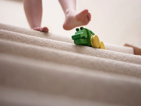 Woman about to slip on toy left on staircase