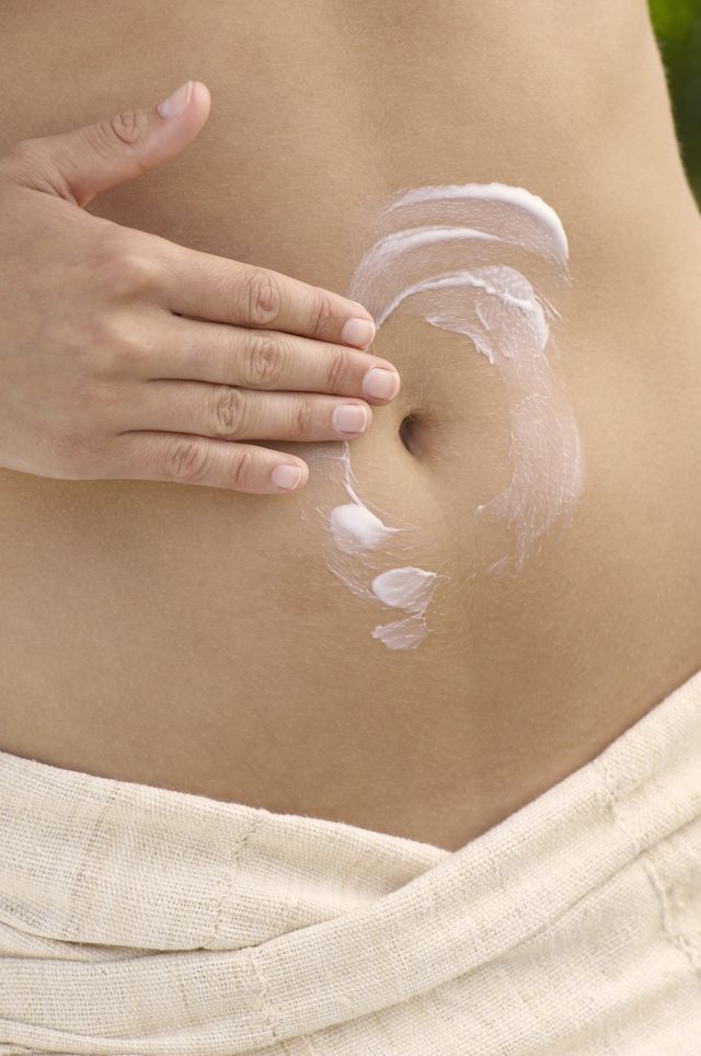 woman applying cream to stomach