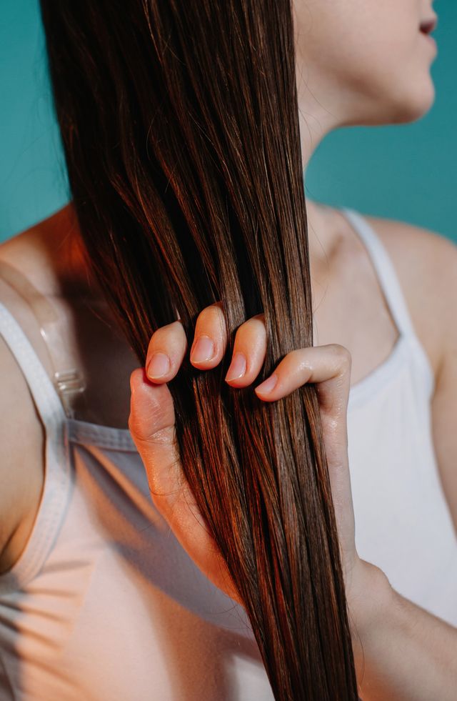 woman applying oil to her hair