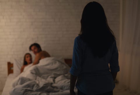 woman catching cheating boyfriend with another girl in their bedroom