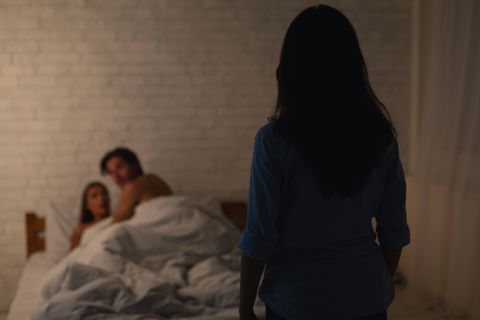 woman catching cheating boyfriend with another girl in their bedroom