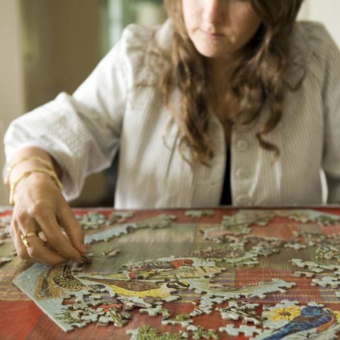 woman doing jigsaw puzzle in home
