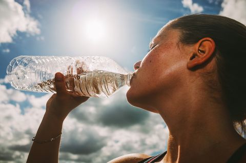 woman drinking water in bright sun light