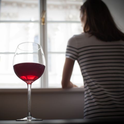 woman drinking wine alone in the dark room