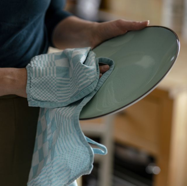 woman drying plate with dish towel, close up