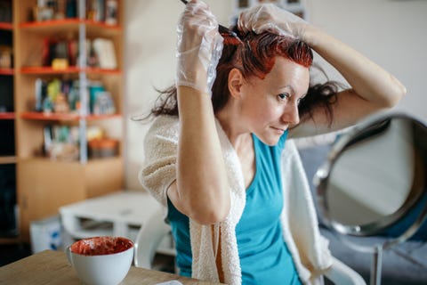 A woman dyes her hair at home