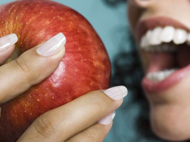 Woman eating apple, close-up