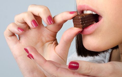 close up of woman eating chocolate