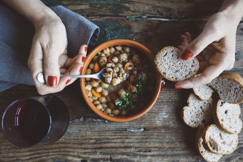 woman eating mediterranean soup with bread, close up